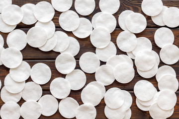 Pattern from cotton pads on wooden background top view