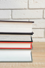 Stack of books in multi-colored covers on a wooden table