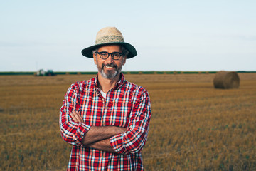 Naklejka na ściany i meble portrait of middle aged rancher standing crossed arms outdoors