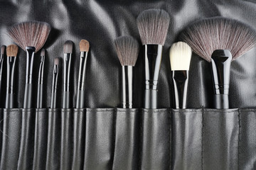 To view. Professional makeup brushes over black background. selective focus