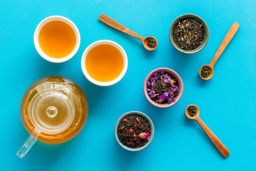 Tea ceremony with leaves and brew on blue background top view