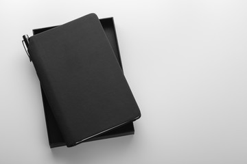 Black notebook with pen holder in box, mockup on grey background, business gift