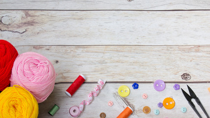 Sewing background. Accessories for needlework on old wooden background.