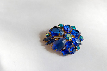 Beautiful antique brooch with bright stones on a white background