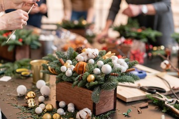 Master class on making decorative ornaments. Flower shop. Christmas decor with their own hands. Woman created a xmas arrangement.