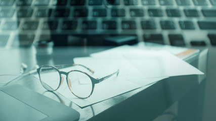 double exposure glasses on table and computer keyboard