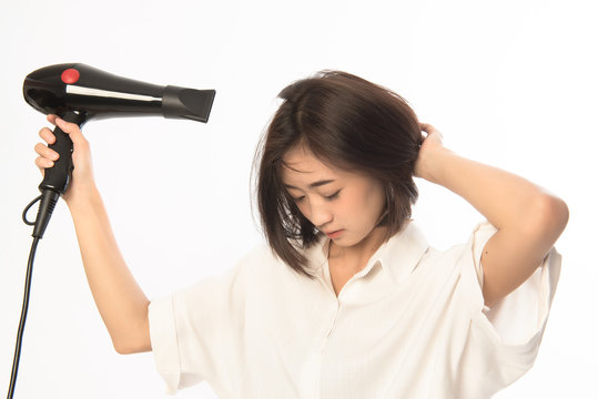 Asian woman uses hair dryer on white background. This image for business woman make up before work.