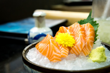 Raw salmon slice or salmon sashimi in Japanese style fresh serve on ice with fresh wasabi