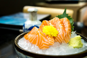 Raw salmon slice or salmon sashimi in Japanese style fresh serve on ice with fresh wasabi
