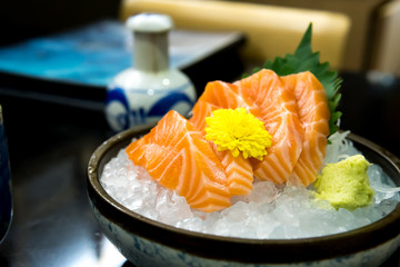 Raw salmon slice or salmon sashimi in Japanese style fresh serve on ice with fresh wasabi