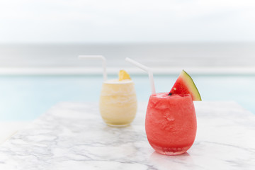Fresh watermelon juice and pineapple juice on mable table in the beach.