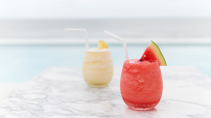 Fresh watermelon juice and pineapple juice on mable table in the beach.