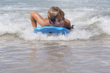 Young boy bodyboarding in the Atlantic ocean