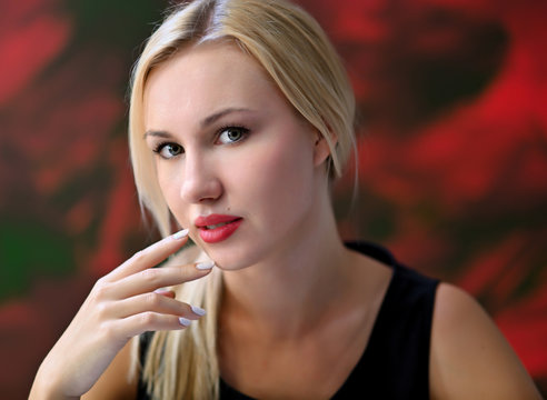 A close-up portrait of a pretty blonde girl with excellent facial skin and light makeup on a colorful background. Beauty, brightness, happiness.