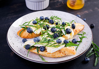Bruschetta. Toast crostini with fresh berries blueberry and honey, brie cheese, arugula. Italian cuisine