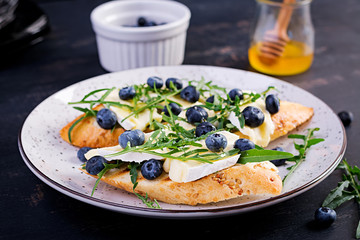 Bruschetta. Toast crostini with fresh berries blueberry and honey, brie cheese, arugula. Italian cuisine