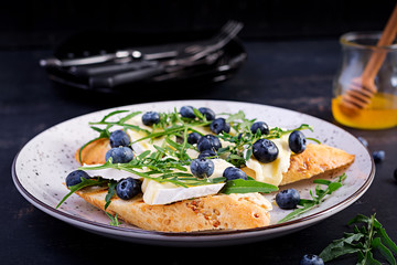 Bruschetta. Toast crostini with fresh berries blueberry and honey, brie cheese, arugula. Italian cuisine