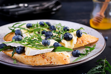 Bruschetta. Toast crostini with fresh berries blueberry and honey, brie cheese, arugula. Italian cuisine