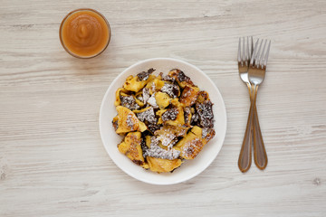 Homemade german Kaiserschmarrn pancake with apple sauce on a white wooden table, top view. Flat lay, overhead, from above.