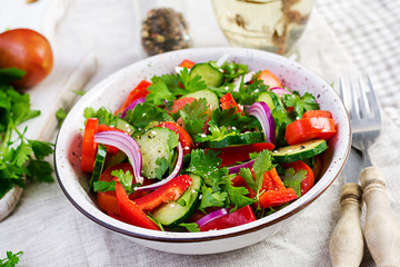 Tomato and cucumber salad with red onion, paprika, black pepper and parsley. Vegan food. Diet menu.