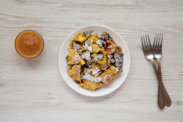 Homemade german Kaiserschmarrn pancake with apple sauce on a white wooden background, top view. Flat lay, overhead, from above.