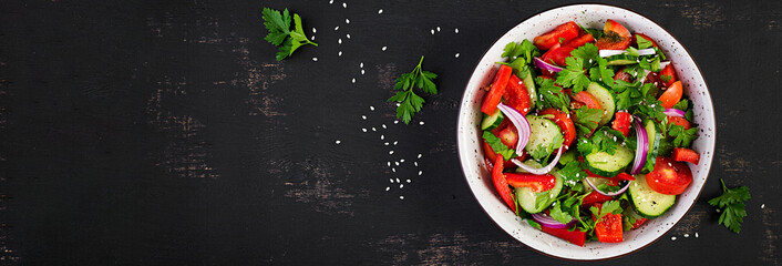 Tomato and cucumber salad with red onion, paprika, black pepper and parsley. Vegan food. Diet menu. Top view. Flat lay