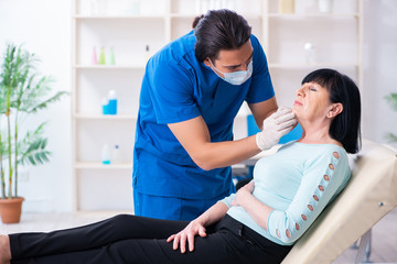 Old woman visiting male doctor for plastic surgery