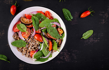 Buckwheat salad with cherry tomatoes, red onion and fresh spinach. Vegan food. Diet menu. Top view. Flat lay