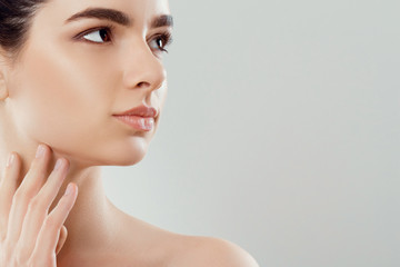 Fototapeta premium Beauty Face. Beautiful Woman With Natural Makeup touch own face. Girl With Clean Fresh Skin. Closeup. Cosmetology. Skincare. High Resolution