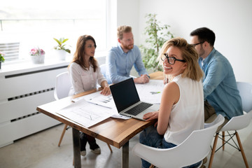 Group of business people working and communicating while sitting at the office desk together