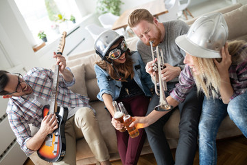 Group of young friends having fun together and playing in music band