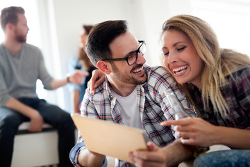 Fototapeta premium Young happy friends relaxing and looking at digital tablet