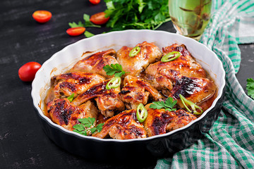 Baked chicken wings in the Asian style on baking dish.