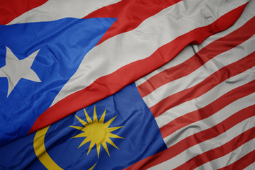 waving colorful flag of malaysia and national flag of puerto rico.