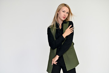 Portrait of a pretty blonde girl in a dark suit on a white background. Beauty, brightness, happiness, business look. Shows different emotions in different poses.