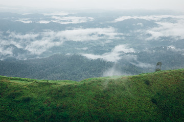 Mountain range with visible silhouettes through the morning colorful fog.