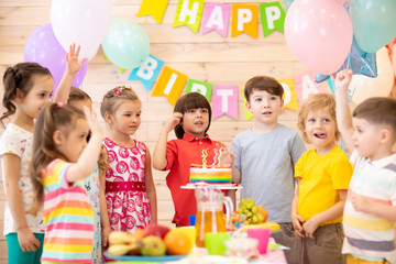 Group of adorable kids gathered around festive table. Birthday children party