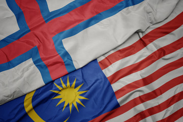 waving colorful flag of malaysia and national flag of faroe islands.