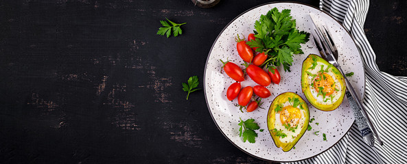Avocado baked with egg and fresh salad. Vegetarian dish. Top view, overhead.  Ketogenic diet. Banner. Keto food