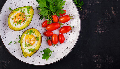 Avocado baked with egg and fresh salad. Vegetarian dish. Top view, overhead.  Ketogenic diet. Keto food