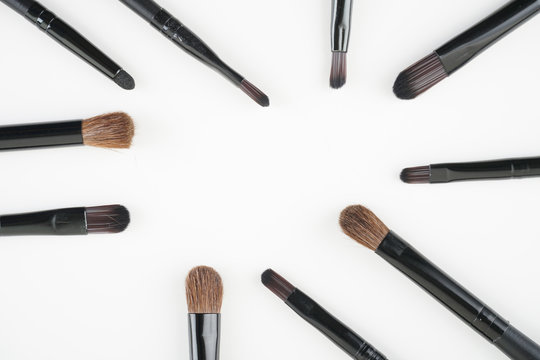 Brown brushes set up over white background. women make up concept. Flat lay, top view. Copy space.