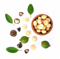 Shelled and unshelled macadamia nuts with leaves isolated on white background. Top view. Flat lay pattern