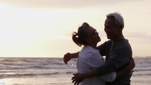 Senior asian couple standing on the beach with happy emotion together. People with lifestyle, emotion and retirement concept.