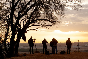 Fotografos fotografiando un atardecer. Situacion real de grupo de fotografos haciendo fotos a un paisaje del skyline de una ciudad europea, Madrid