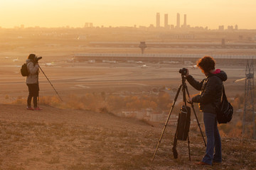 Fotografos fotografiando un atardecer. Situacion real de grupo de fotografos haciendo fotos a un paisaje del skyline de una ciudad europea, Madrid