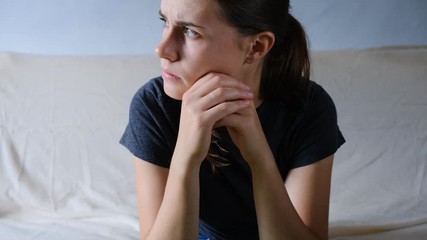 Close up desperate woman sit on sofa looking away feel depressed doubtful, lonely stressed upset young  girl thinking of psychological problem thinking regret about mistake
