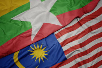 waving colorful flag of malaysia and national flag of myanmar.