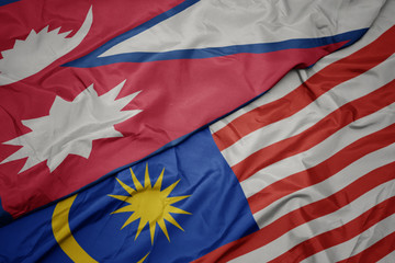waving colorful flag of malaysia and national flag of nepal.