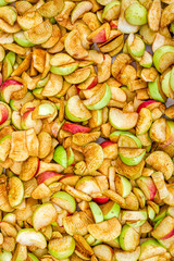 Sliced red and green apples are prepared for drying.