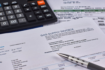 Gas supply invoice, utility bill with calculator and pen. Close-up